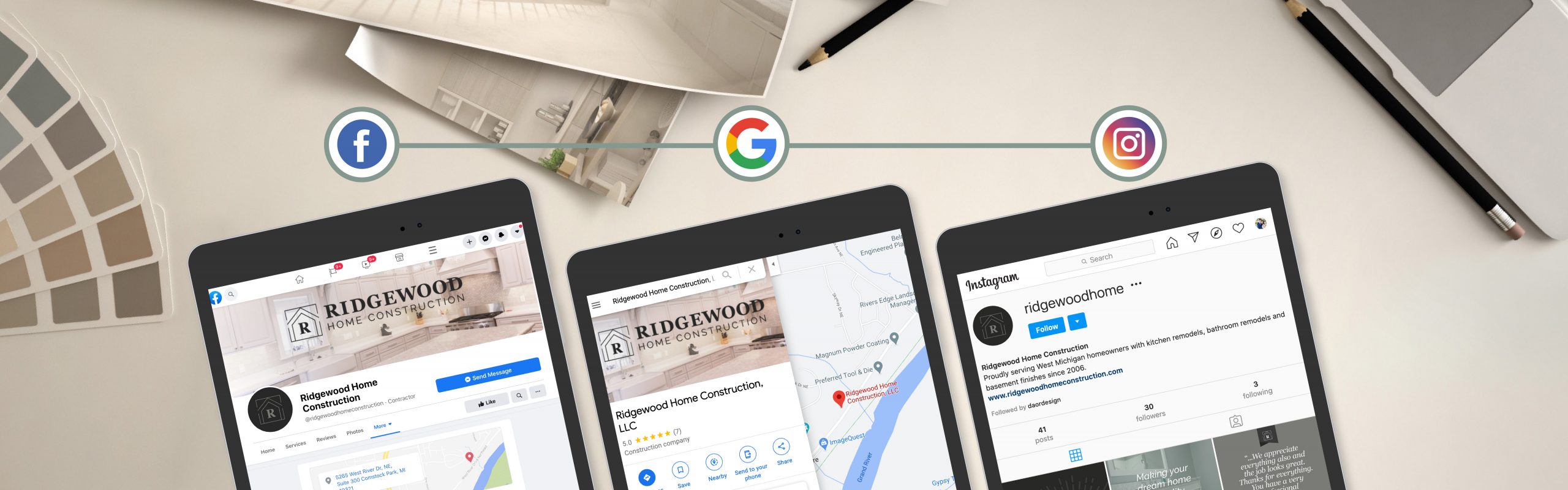 Three tablets displaying the Facebook, Google, and Instagram pages for a business named "Ridgewood Home Construction" are laid out on a white surface, surrounded by office items such as a clipboard,