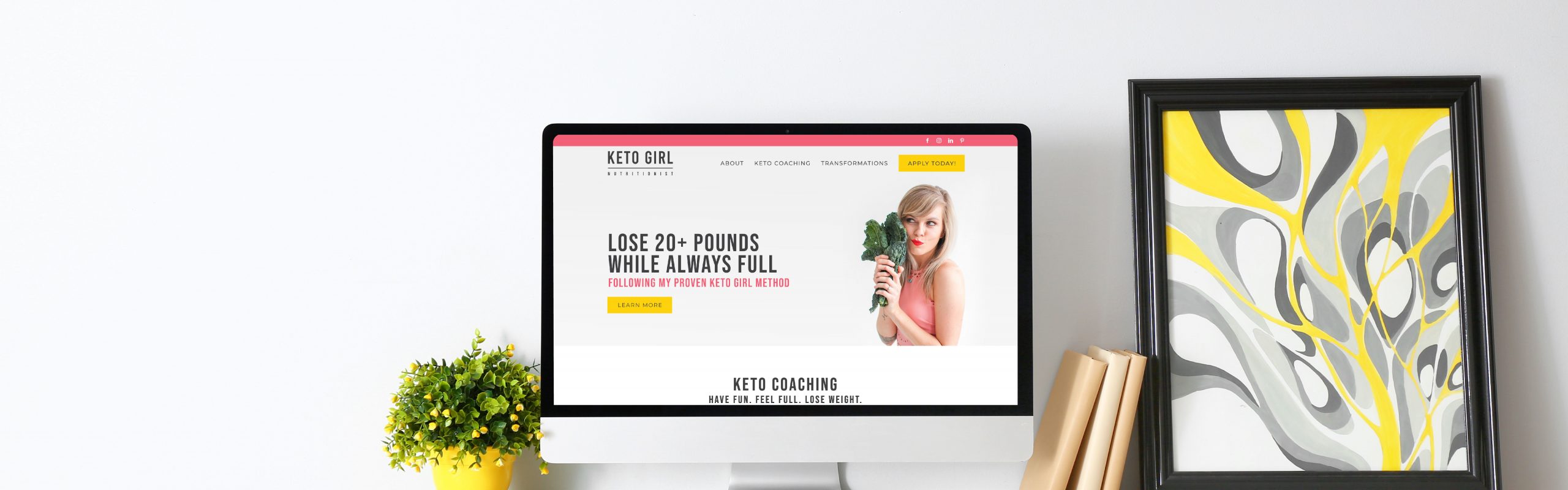 A computer monitor displaying a weight loss program advertisement titled "Keto Diet" with a nutritionist holding a measuring tape around her waist on a clean desk, accompanied by a framed piece of art.