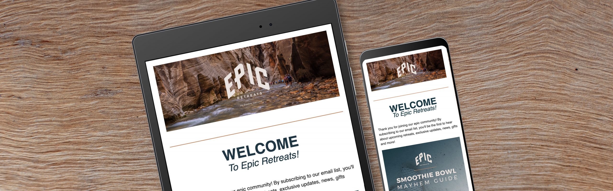 A laptop and a smartphone resting on a wooden surface display the homepage of Epic Retreats, featuring a welcome message.