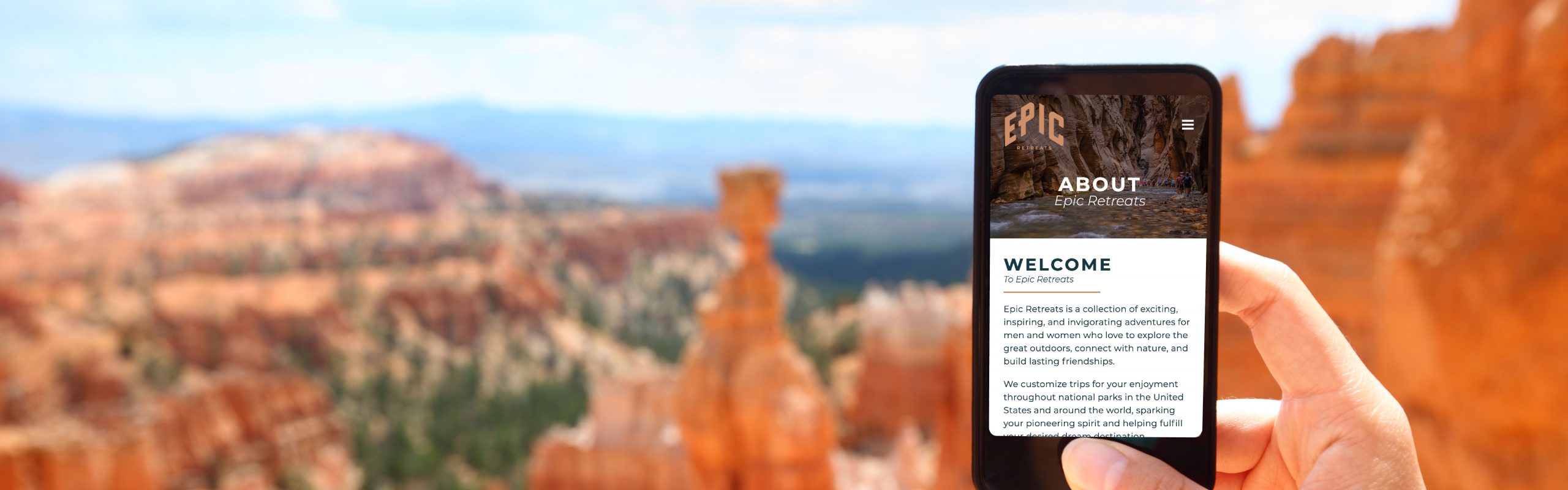 A person's hand holding a smartphone with an "Epic Retreats" page open, against the backdrop of a scenic red rock canyon.