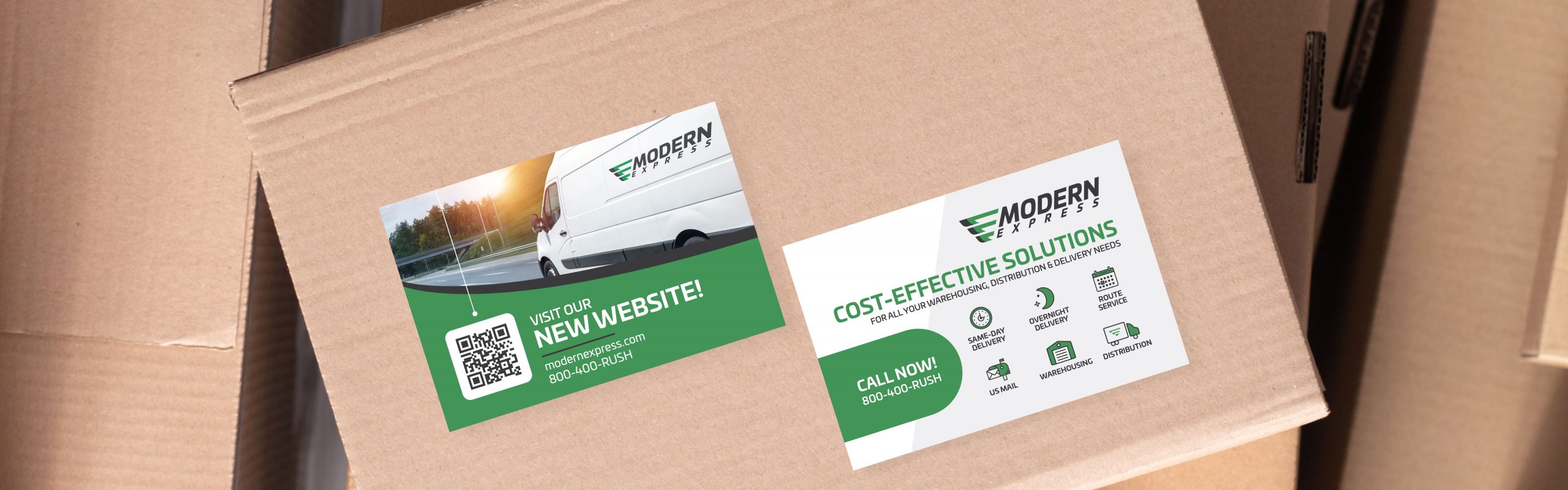 Two cardboard boxes with printed promotional flyers on top showcasing advertisements for Modern Express's new website and cost-effective solutions.
