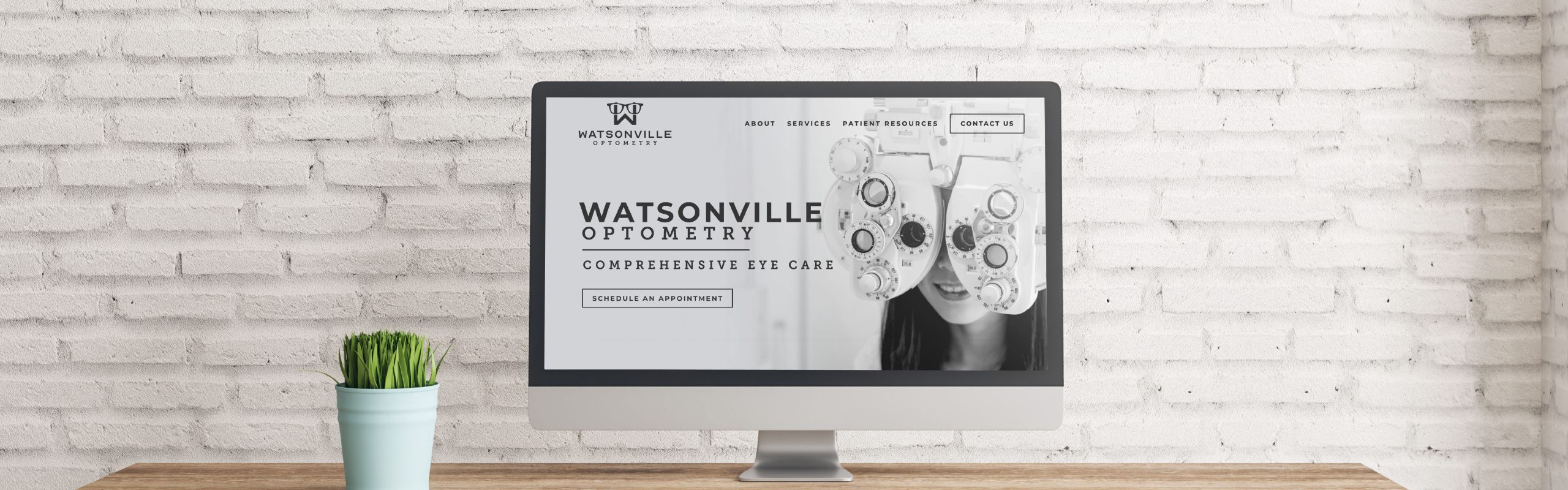A computer monitor on a desk displaying the homepage of watsonville optometry, which offers comprehensive eye care services.